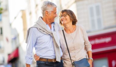 Smiling older couple walking arm-in-arm outdoors, symbolizing retirement planning, financial freedom, and enjoying life after reaching savings goals.