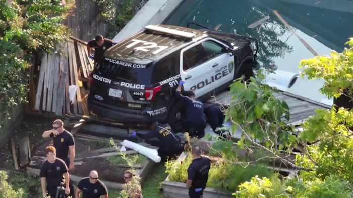 Houston police SUV crashes through fence, dangles in family’s pool in The Heights