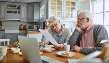Close up of a senior couple having breakfast and doing bills.