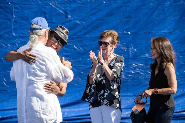 Artist Robert Vargas is hugged by activist Edward James Olmos...