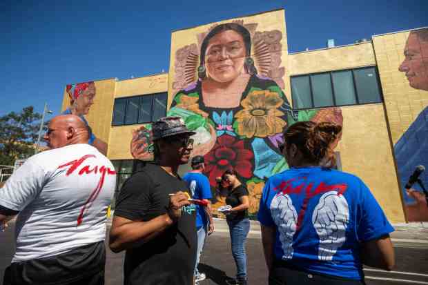 Artist Robert Vargas signs shirts after his “Nourishing the Community”...