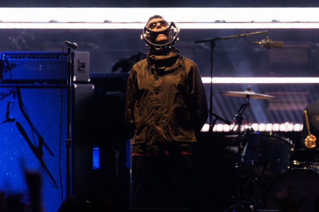 Liam Gallagher, lead singer of Oasis performs with members of...