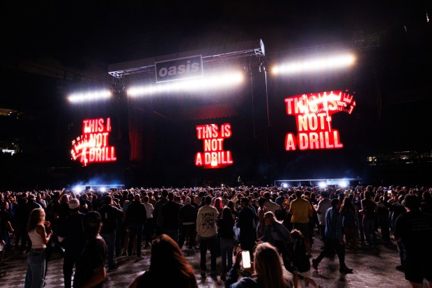 Fans watch Oasis perform a Soldier Field on Aug. 28,...