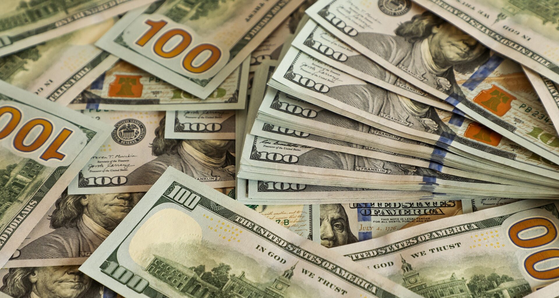 Stacks of 100 US dollar bills scattered closely together. Concept of wealth, financial success, banking, investment, income, and economic prosperity. stock photo