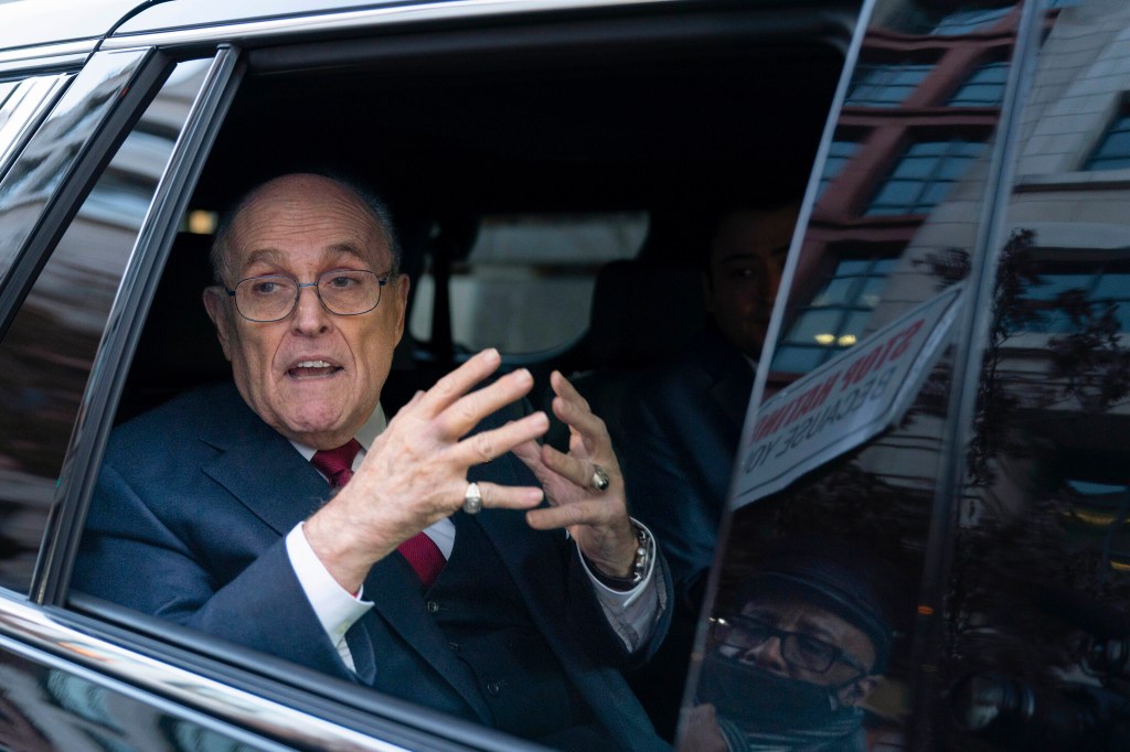 Rudy Giuliani in a car, speaking.