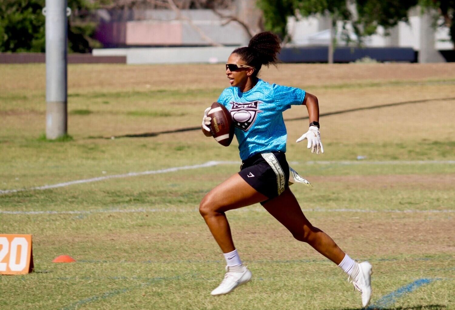 Cydeni Carter, sprinting with a football in a Phoenix Gay Flag Football League game, said she enjoys the league because there are “people who are around me who are just like me.” (Photo courtesy of Steph Ramos/Oro Hour Photos)