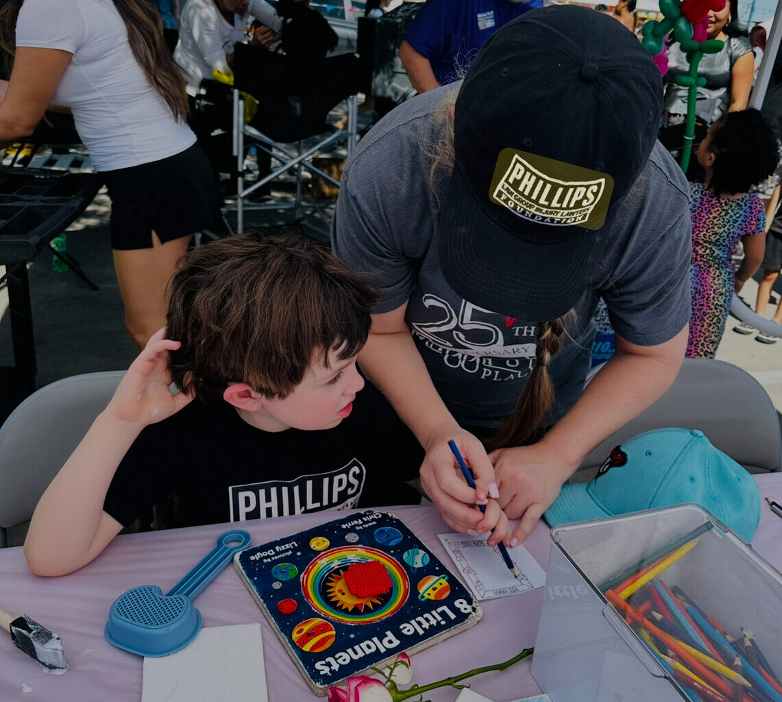 A volunteer works with a boy at a Phillips Law Foundation event. The group is among the list of nonprofits celebrating National Nonprofit Day — a day “dedicated to recognizing the efforts” of nonprofit groups and their contributions to the community, according to Societ, which partners with nonprofit groups.