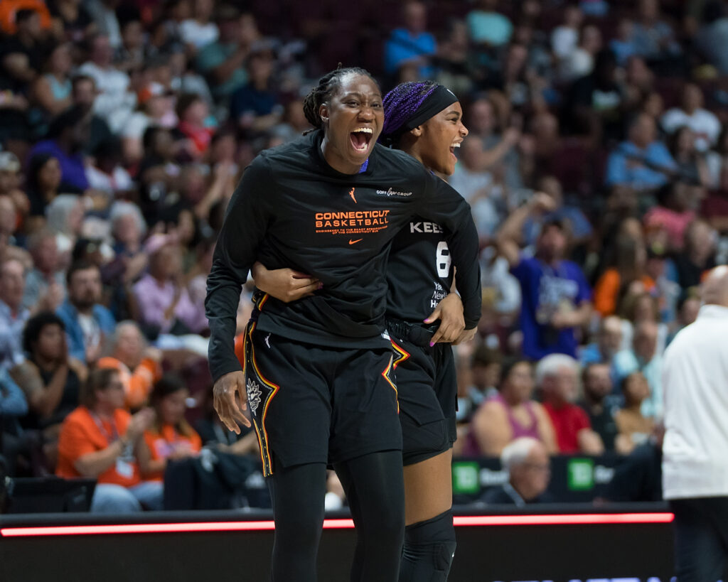 Aaliyah Edwards and Tina Charles smiling and celbrating a shot.