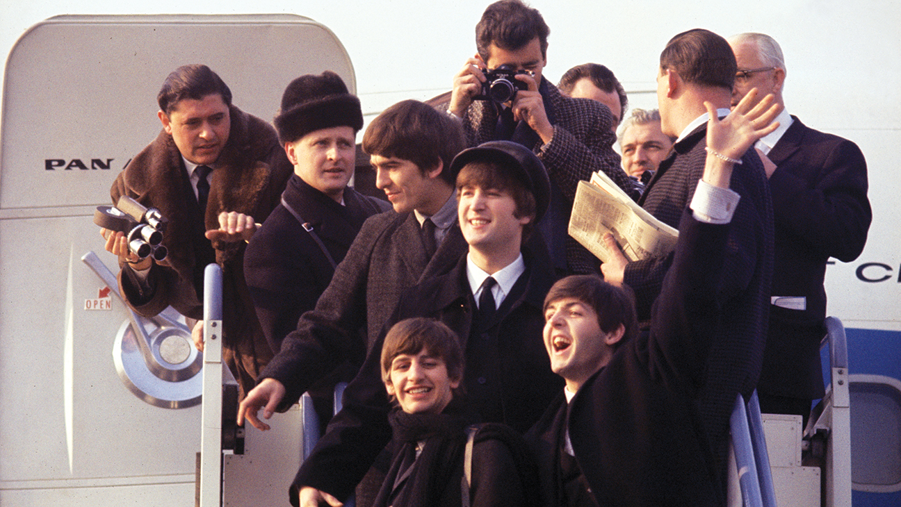 (L-R) George Harrison, Ringo Starr, John Lenon, and Paul Mccartney arriving at JFK airport in 'Beatles 64.'