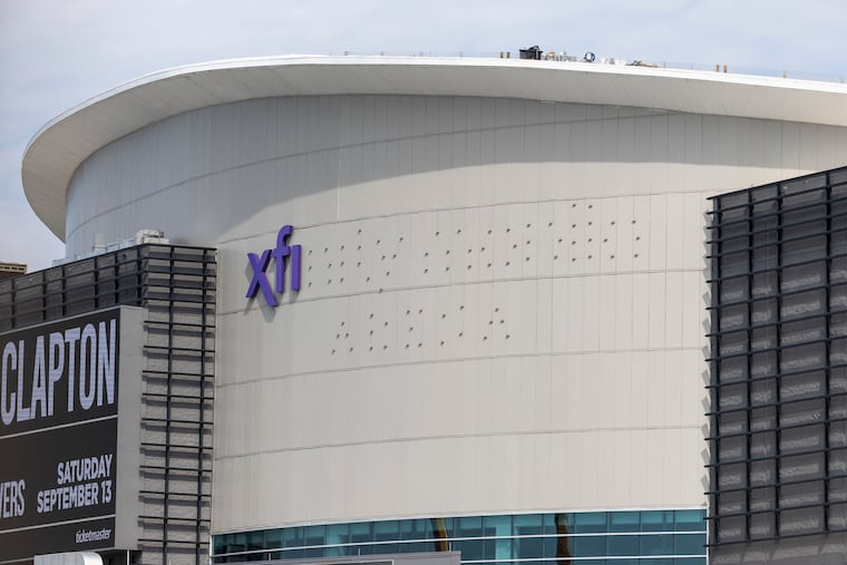 Workers putting up the Xfinity Mobile Arena signage at the Wells Fargo Center on Thursday.