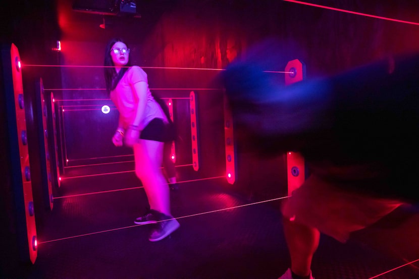 Natalie Fontenot and Ben Johnson of Wichita Falls, Texas maneuver their way through lasers...