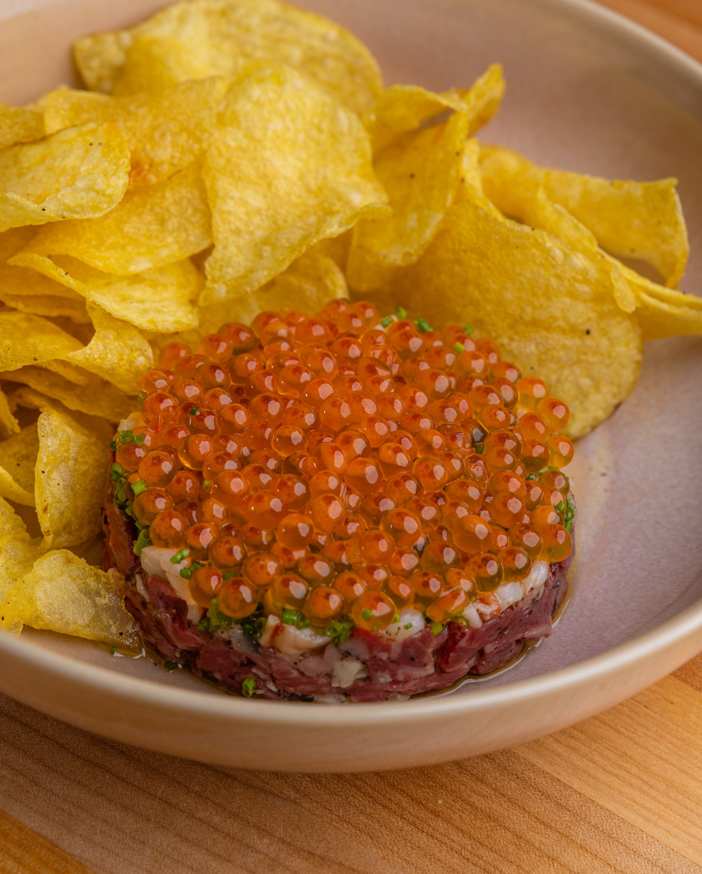Raw minced Wagyu, roe, shallot, celery, anchovy aioli, truffle chips at Dom’s Taverna.