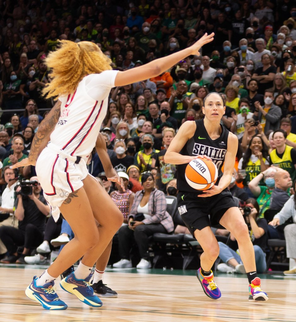 Storm point guard Sue Bird (10) sets up a pass around Mystics center Shakira Austin (0). Austin holds her right arm up to try and block the passing lane.