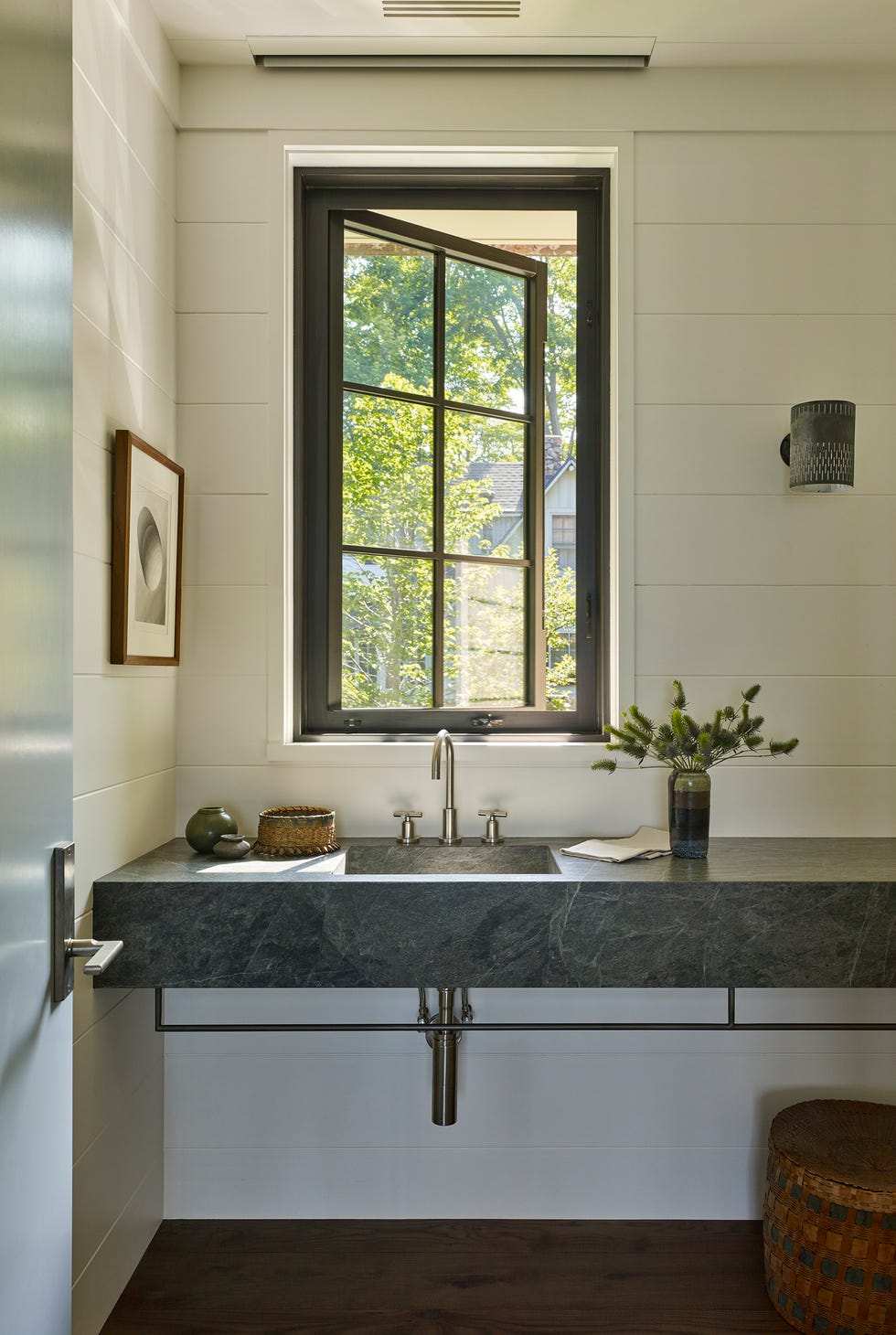 Modern bathroom sink area with a large window.