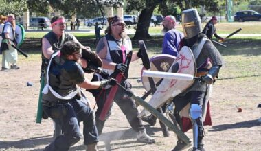 Several players battle with swords, decked out in armor and protective gear.