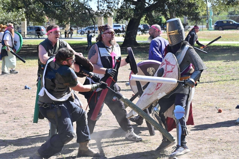 Several players battle with swords, decked out in armor and protective gear.