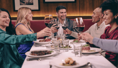 A group clinks wine glasses at a fancy restaurant.