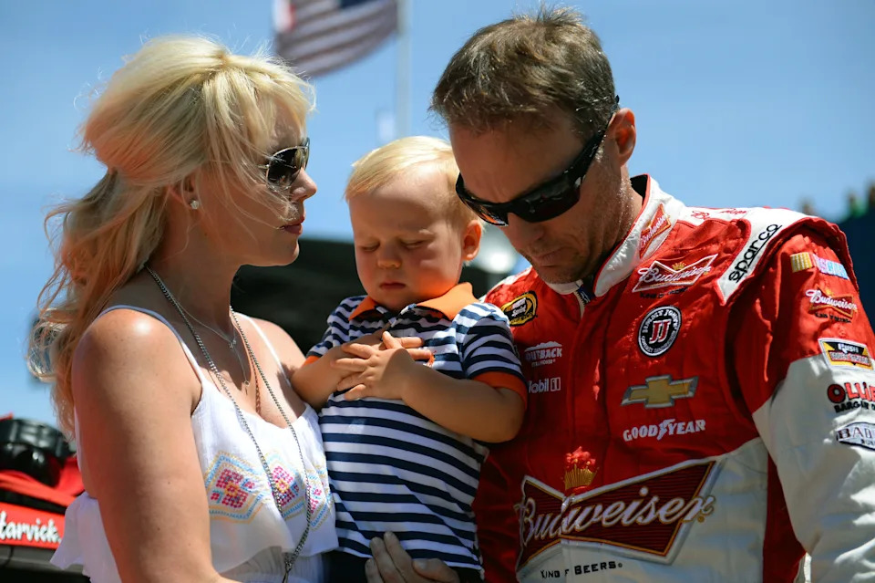 Kevin Harvick (right), driver of the #4 Budweiser Chevrolet, stands with his wife Delana (left) and their son Keelan on the grid prior to the NASCAR Sprint Cup Series Quicken Loans 400 at Michigan International Speedway.