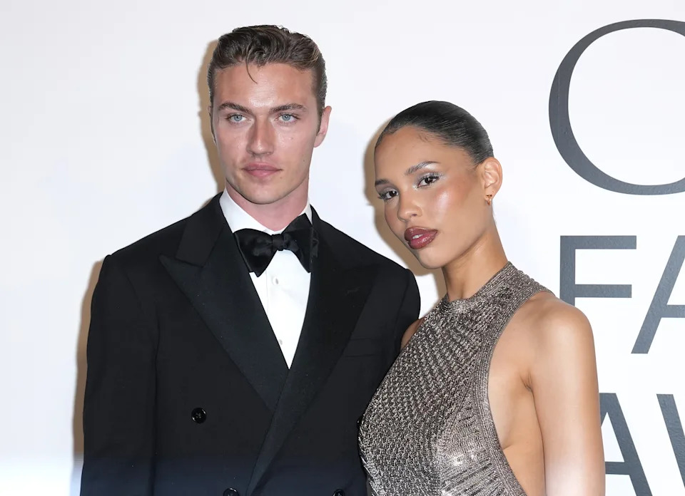 Lucky Blue Smith in a black tuxedo and Nara Smith in a sparkly, sleeveless dress pose together at an event