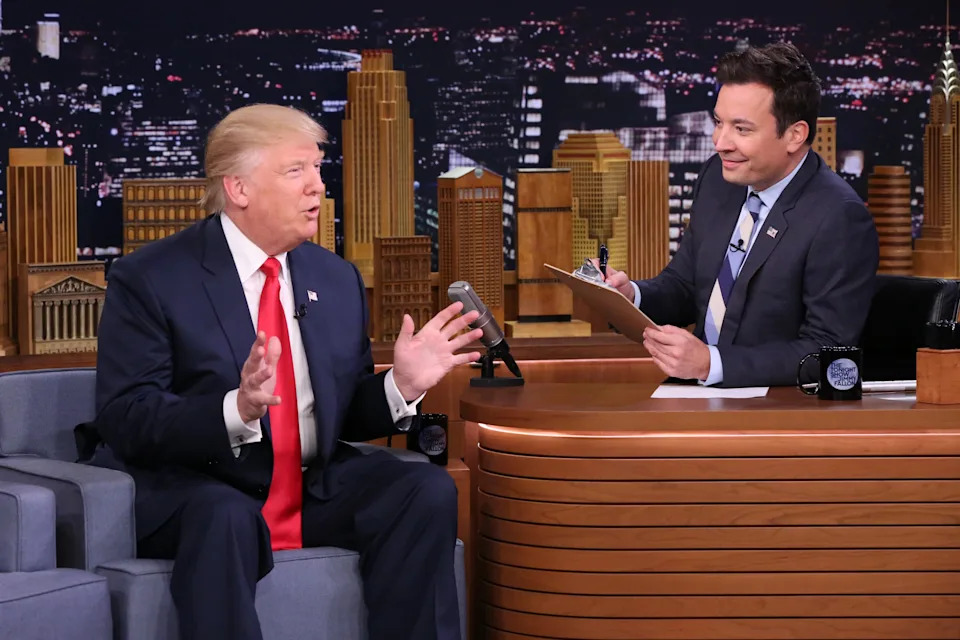 Donald Trump and Jimmy Fallon talk on The Tonight Show in front of a cityscape background