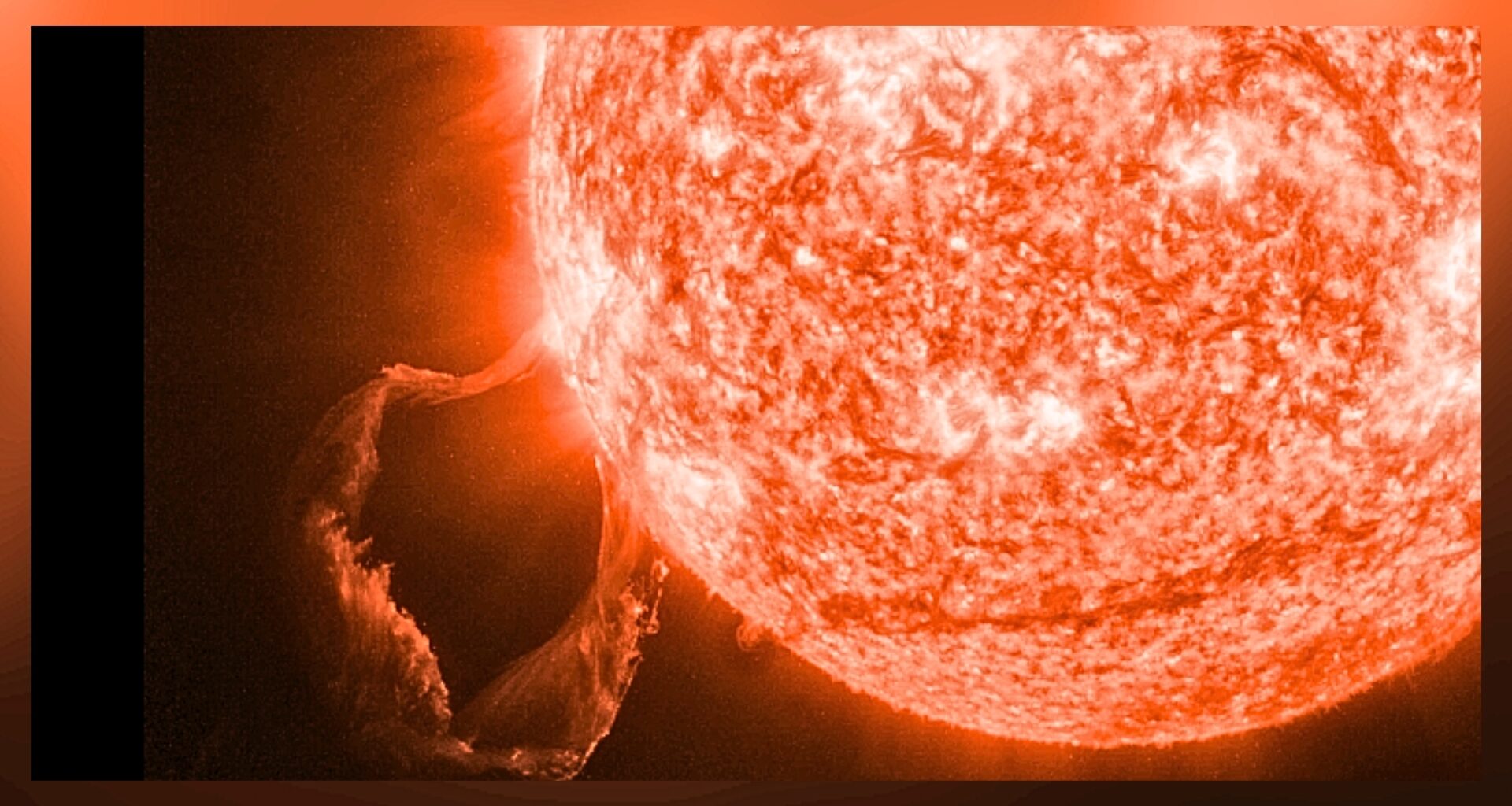 a close up view of the sun erupting with a large prominence looping in the bottom left corner of the image.