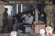 Migrants sit on a military aircraft at Fort Bliss in El Paso on Jan. 30, 2025, awaiting...