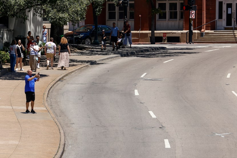 A man takes a photo of the spot where President John F. Kennedy was shot in Dealey Plaza,...