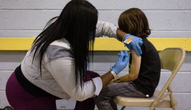 A healthcare worker administers a dose of the Covid-19 vaccine to a child.