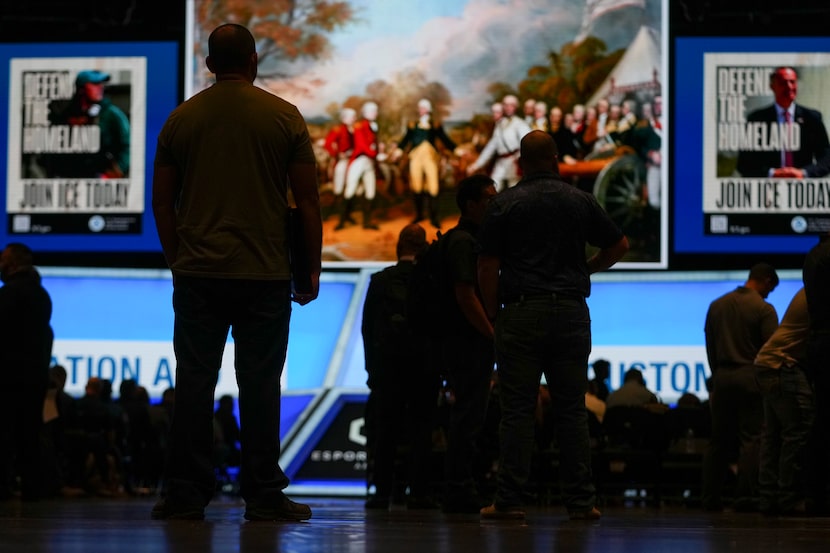 A photograph of George Washington is displayed on the stage as people gather during an ICE...