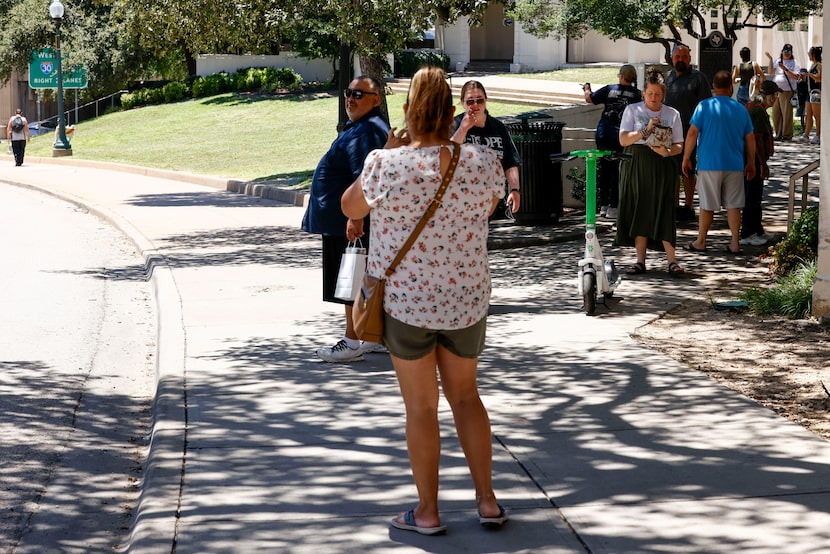 People visit and take photos in Dealey Plaza, Wednesday, July 23, 2025, in Dallas.