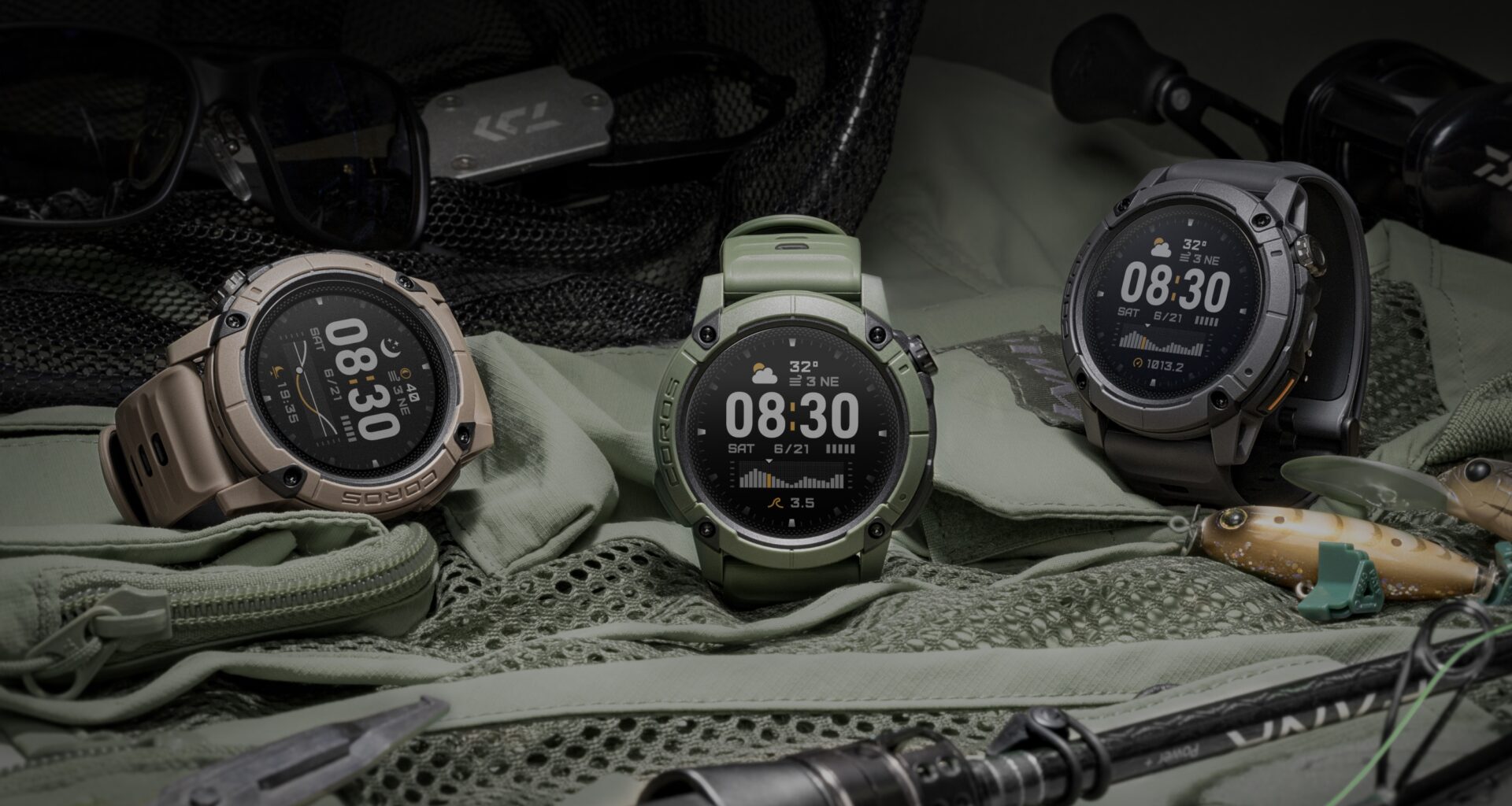 A photo of the green, grey, and brown COROS NOMAD watches sitting on a tent with camping equipment nearby.