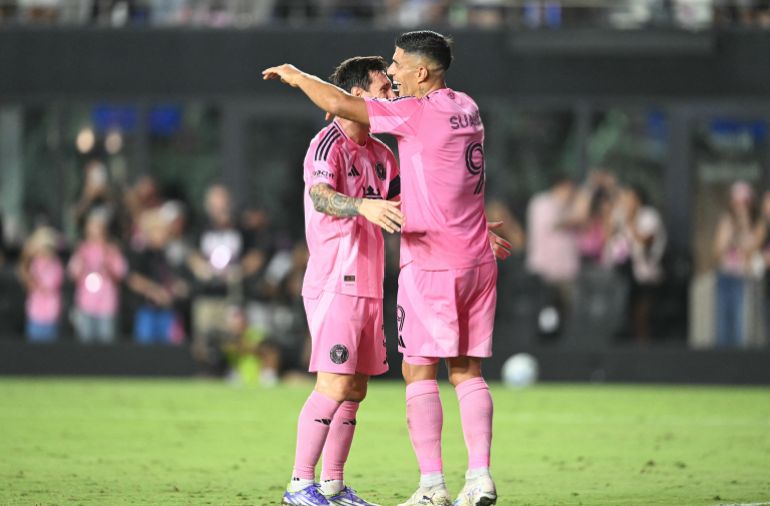 Luis Suarez and Lionel Messi react.