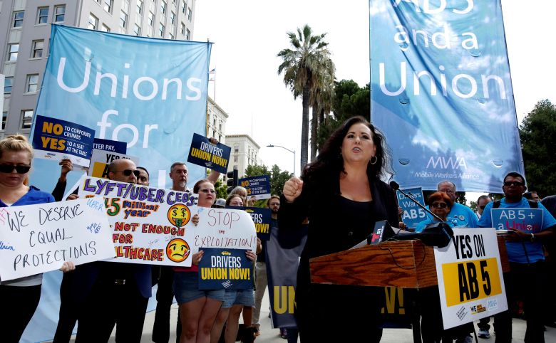 People demonstrating in support of AB 5 with signs for union rights.