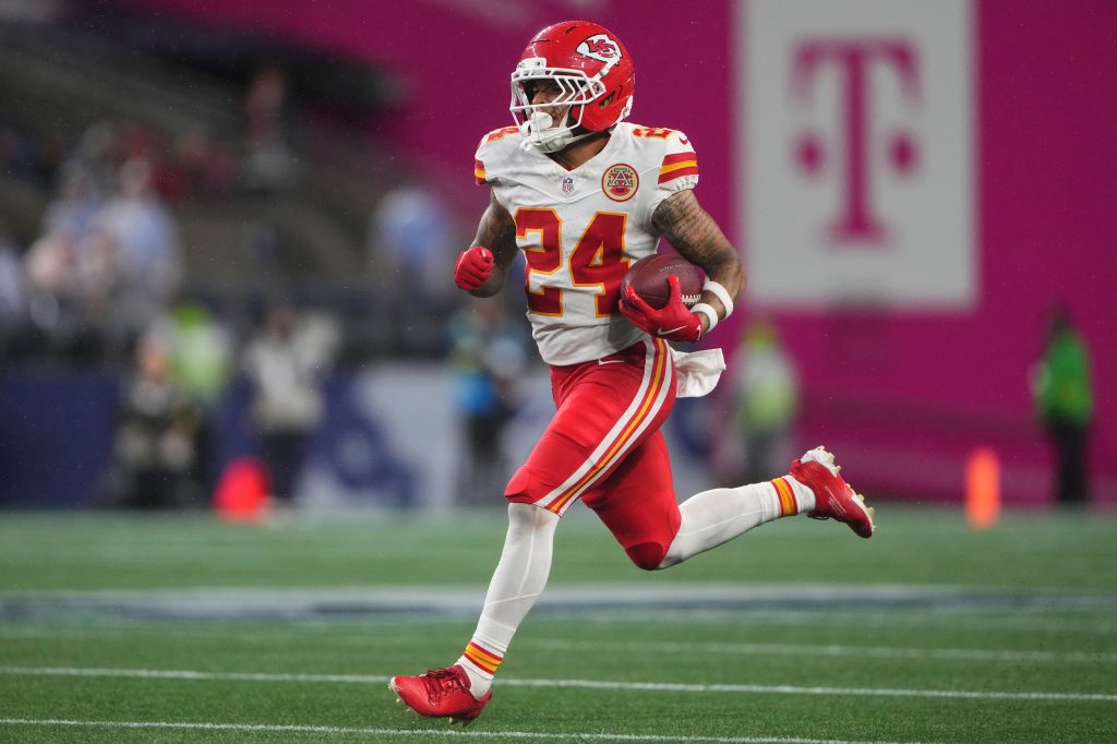 Kansas City Chiefs player running with the football.