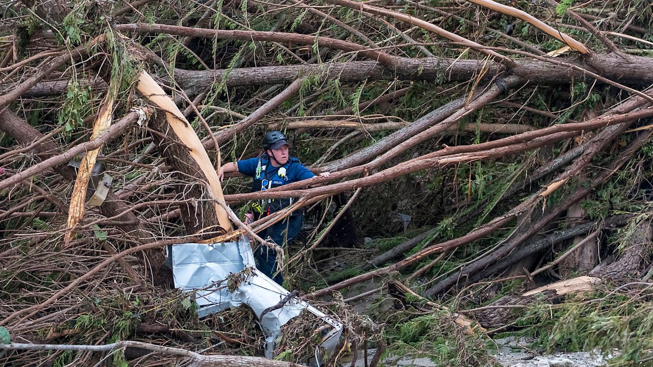 First responders from College Station Fire Department search along the banks of the Guadalupe River, as rescue efforts continue following extreme flooding, July 6, 2025, in Ingram, Texas. (AP Photo/Rodolfo Gonzalez)