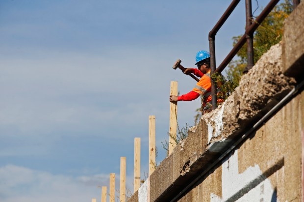 Workers place fencing on the Bloomingdale Trail or also known...