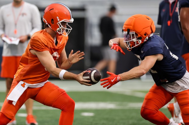Illinois quarterback Luke Altmyer hands off to running back Aidan Laughery during practice at Memorial Stadium on Aug. 7, 2025, in Champaign. (Armando L. Sanchez/Chicago Tribune)