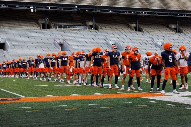 Illinois players stand on the field during practice at Memorial Stadium on Aug. 7, 2025, in Champaign. (Armando L. Sanchez/Chicago Tribune)