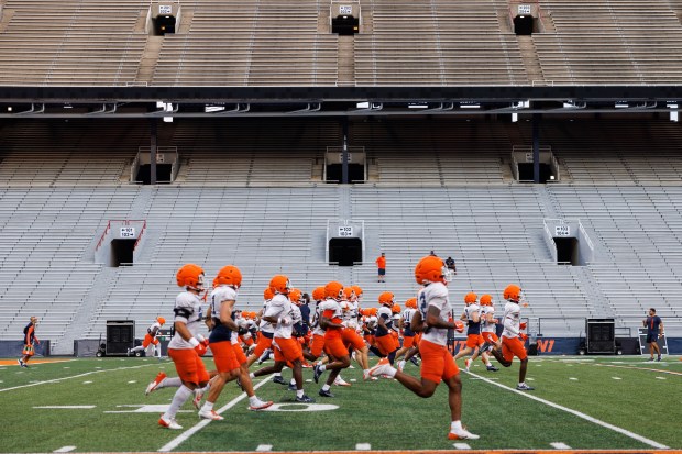 Illinois players run on the field during practice at Memorial Stadium on Aug. 7, 2025, in Champaign. (Armando L. Sanchez/Chicago Tribune)