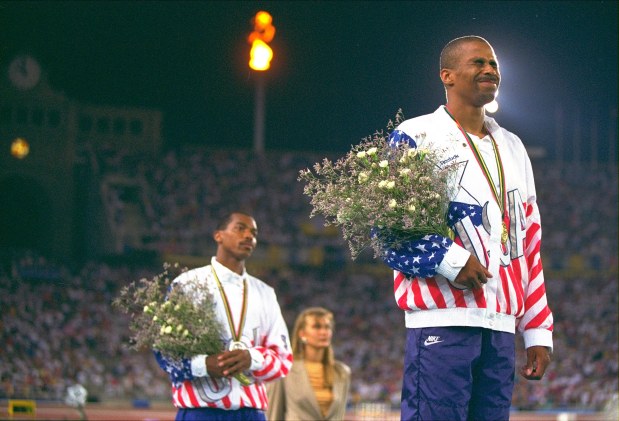 U.S. triple jump silver medalist Charles Simpkins of Aiken, S.C., left, and gold medalist Mike Conley of Fayetteville, Ark., stand on the winners platform, on Aug. 3, 1992, in Barcelona. (Eric Risberg/AP)