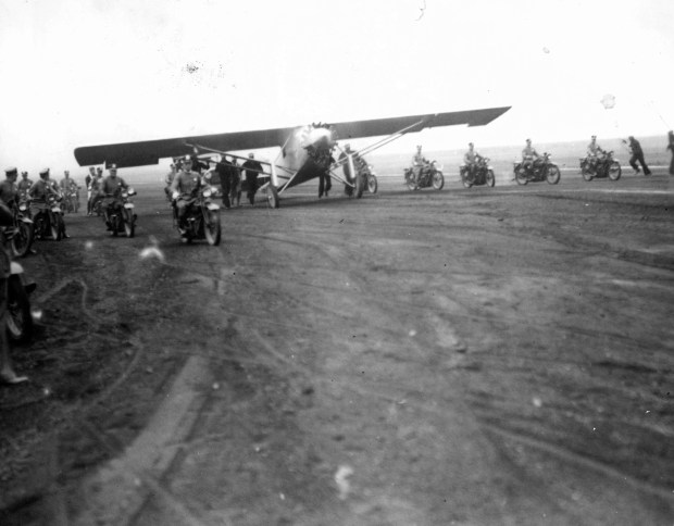 Police on motorcycles escort Col. Charles Lindbergh as his plane taxied up to a hanger on Aug. 13, 1927, at Municipal Airport (now called Chicago's Midway International Airport), after flying over Chicago's downtown area, including Soldier Field. Lindy left his plane at the hanger and returned to Soldier Field to deliver a speech on the importance of commercial aviation. (Chicago Tribune historical photo)