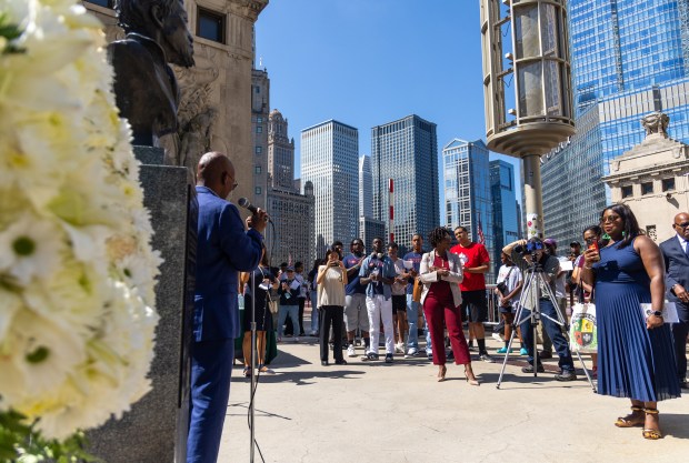 Guests listen as Jean Voltaire, board member of the DuSable...