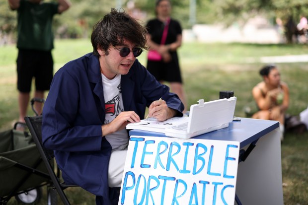 Jacob Ryan Reno draws a "terrible" portrait of a group of people in Logan Square on Aug. 10, 2025. (Eileen T. Meslar/Chicago Tribune)