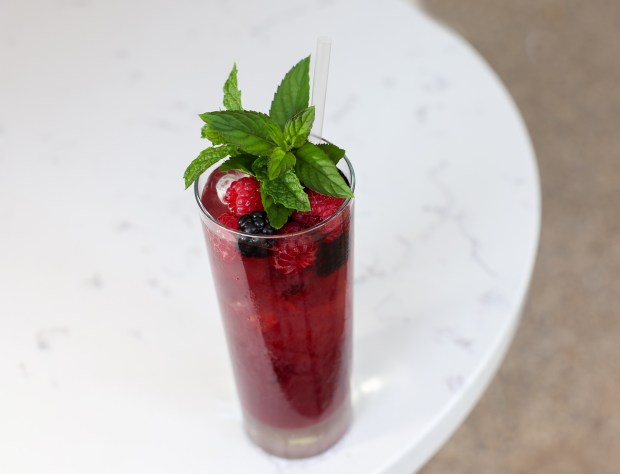 The daily agua fresca in glass with fresh berries and...