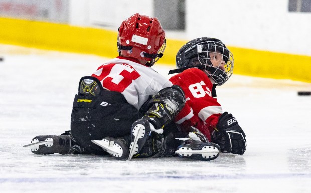 Archie DeBrincat, left, and Patrick Kane III wrestle on the ice during Patrick Kane Day Friday, Aug. 8, 2025 at Johnny's Ice House West in the United Center neighborhood of Chicago. The City of Chicago officially named Aug. 8 Patrick Kane Day. Their fathers Alex DeBrincat and Patrick Kane play on the Detroit Red Wings together and both attended the event. (Dominic Di Palermo/Chicago Tribune)