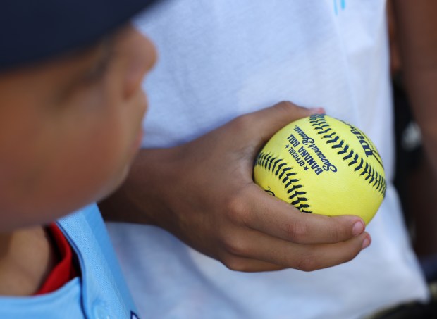 A fan holds a Savannah Bananas baseball before a game between the Bananas and Firefighters on Aug. 15, 2025, at Rate Field. (John J. Kim/Chicago Tribune)