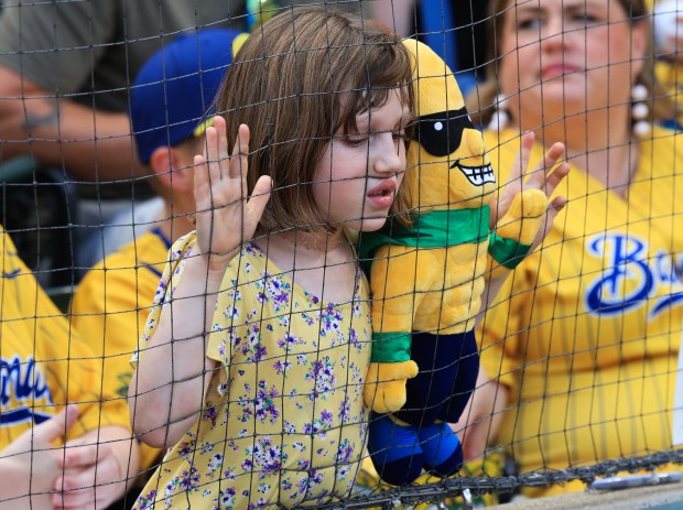 A young fan holds a Savannah Bananas mascot stuffed toy as she leans in on the security netting before a game between the Savannah Bananas and Firefighters on Aug. 15, 2025, at Rate Field. (John J. Kim/Chicago Tribune)