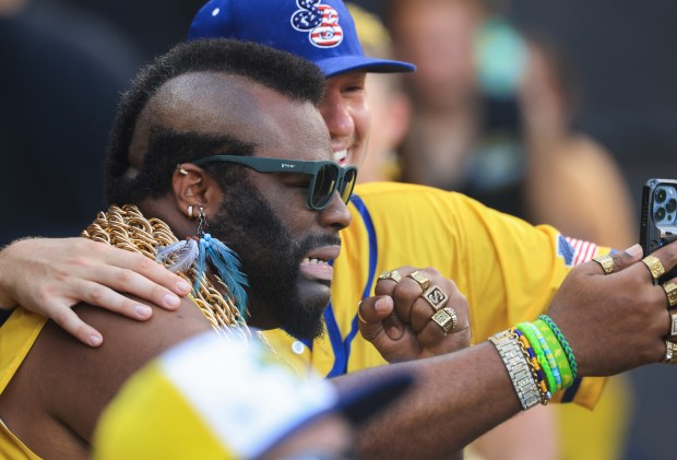 A Savannah Bananas cast member dressed as Mr. T takes pictures with players before a game against the Firefighters on Aug. 15, 2025, at Rate Field. (John J. Kim/Chicago Tribune)
