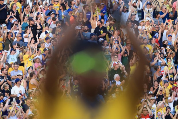 Fans rise during a pregame activity for a game between the Savannah Bananas and Firefighters on Aug. 15, 2025, at Rate Field. (John J. Kim/Chicago Tribune)