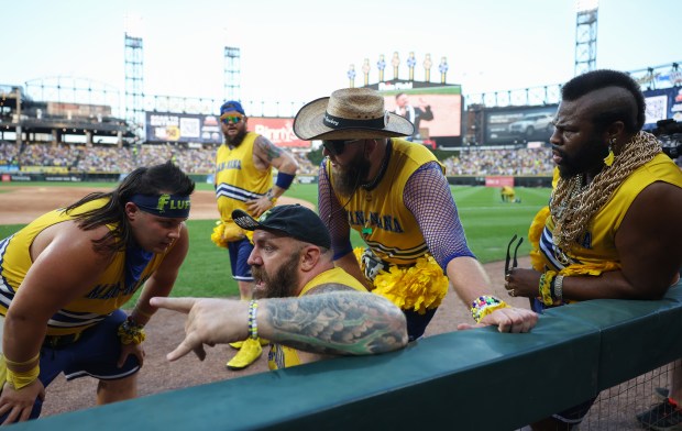 Members of the Dad Bod Cheer Squad rest after performing before a game between the Savannah Bananas and Firefighters on Aug. 15, 2025, at Rate Field. (John J. Kim/Chicago Tribune)